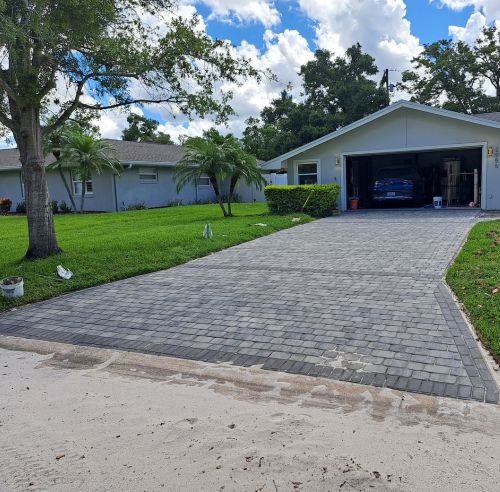 A driveway with a car parked in it